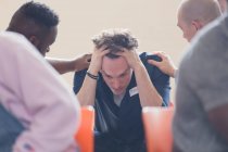 Männer trösten verärgerten Mann in Gruppentherapie — Stockfoto