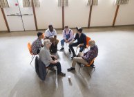 Men talking in group therapy circle — Stock Photo