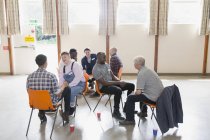 Чоловіки розмовляють груповою терапією в громадському центрі — стокове фото