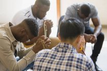 Чоловіки моляться з розаріями в молитовній групі — стокове фото