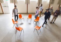 Men arriving at group therapy, sitting in circle in community center — Stock Photo