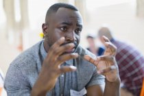 Serious young man talking, gesturing in group therapy — Stock Photo