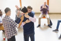 Чоловіки обіймаються і плескаються в груповій терапії — стокове фото