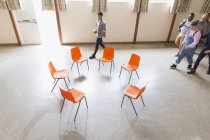 Männer kommen, nähern sich Stühlen im Kreis im Gemeindezentrum — Stockfoto
