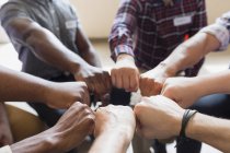 Men joining fists in circle in group therapy — Stock Photo
