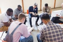 Мужчины читают и обсуждают Библию в молитвенной группе — стоковое фото