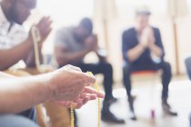 Чоловіки моляться з розаріями в молитовній групі — стокове фото