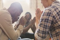 Männer beten mit Rosenkranz in Gebetsgruppe — Stockfoto