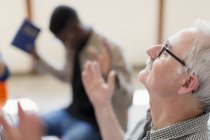 Senior Mann mit dem Kopf zurück betet in Gebetsgruppe — Stockfoto