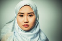 Portrait confident, serious young woman wearing blue silk hijab — Stock Photo