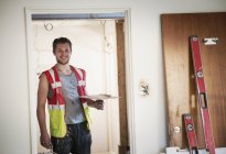 Porträt lächelnder Bauarbeiter beim Verputzen von Haus — Stockfoto