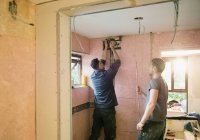 Trabajadores de la construcción instalando tubería de cobre en casa - foto de stock