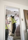 Construction workers plastering ceiling in house — Stock Photo