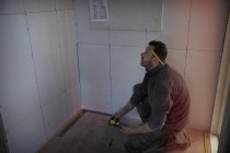 Trabajador de la construcción usando herramienta de medición láser - foto de stock