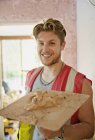 Portrait smiling, confident young construction worker plastering — Stock Photo