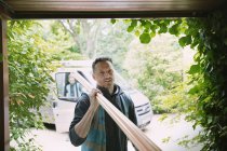 Porträt selbstbewusster Tischler trägt Geräte in Garage — Stockfoto