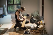Construction worker preparing hardwood flooring in house — Stock Photo