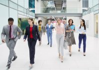 Business people walking in modern office atrium lobby — Stock Photo
