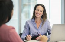 Smiling, confident businesswoman listening in conference room meeting — Stock Photo