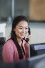 Улыбающаяся деловая женщина разговаривает по телефону в офисе — стоковое фото
