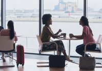 Empresárias conversando e bebendo café no lounge de negócios do aeroporto — Fotografia de Stock