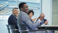 Sorrindo homem de negócios batendo palmas na reunião da sala de conferências — Fotografia de Stock