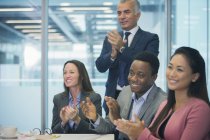 Business people smiling and clapping in conference room meeting — Stock Photo