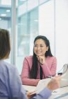 Smiling, attentive businesswoman listening to colleague in meeting — Stock Photo