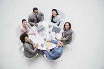Retrato de alto ângulo sorrindo, empresários confiantes se encontrando na mesa redonda — Fotografia de Stock