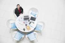 Retrato de alto ângulo empresária confiante sentada na mesa redonda — Fotografia de Stock