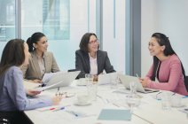 Smiling businesswomen talking in conference room meeting — Stock Photo