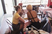 Junge Freundinnen essen im Restaurant — Stockfoto