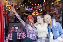 Überschwängliche junge Freundinnen an der Bar — Stockfoto