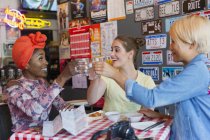 Felice giovane donne amiche brindare cocktail nel bar — Foto stock
