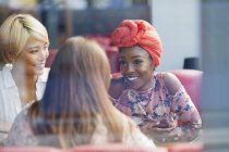 Молоді жінки друзі розмовляють в кафе — стокове фото