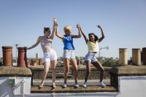Giovani amiche spensierate che ballano sul soleggiato tetto estivo — Foto stock