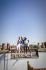Young women friends taking selfie with camera phone on sunny rooftop — Stock Photo