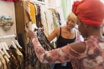 Молоді жінки друзі купують в магазині одягу — стокове фото