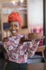Retrato confiante jovem mulher carregando bolo de aniversário — Fotografia de Stock