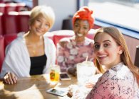 Портрет впевнені, усміхнені молоді жінки друзі їдять в ресторані — стокове фото