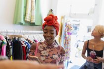 Молодая женщина использует смартфон в магазине одежды — стоковое фото