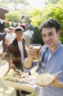 Retrato homem feliz bebendo cerveja e churrasco no quintal — Fotografia de Stock