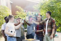 Feliz amigos do sexo masculino brindar bebidas sobre churrasqueira no quintal — Fotografia de Stock