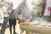 Male friends barbecuing in back yard — Stock Photo