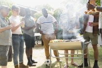 Masculino amigos beber cerveja e churrasco no ensolarado verão quintal — Fotografia de Stock