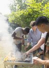 Amis masculins au barbecue grill dans la cour ensoleillée — Photo de stock