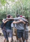 Чоловіча група обіймається в тулубі, пішохідний туризм у лісі — стокове фото