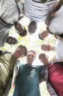 View from below mens group standing in huddle — Stock Photo