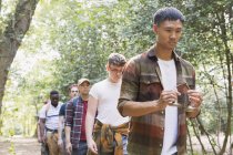 Man with tingsha cymbals leading mens group hike in woods — Stock Photo