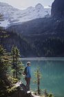Randonneuse regardant un lac de montagne idyllique ensoleillé, Parc Yoho, Colombie-Britannique, Canada — Photo de stock